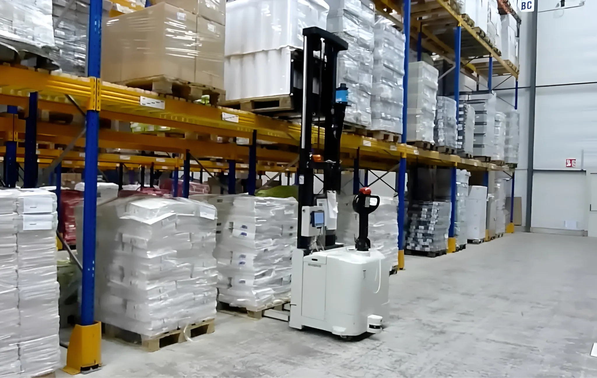 AGV gerbeur compact qui prend en charge une manutention en hauteur sur un étage de stockage